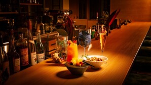Eine Bar mit Flaschen, Gläsern und einer Schale Nüsse.