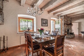 A dining area with a wooden table set for four, surrounded by chairs.