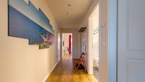 A hallway with wooden flooring, a red chair, and a door with a white frame. - Modern Vacation Apartment "Büsumperle Rot" in Central Location with Wi-Fi (Büsum)