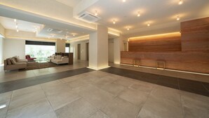 A spacious lobby with a reception desk, seating area, and a large window providing natural light. - Hotel Meriken Port Kobe Motomachi (Kobe)