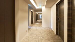 A long, narrow hotel corridor with carpeted floors and wooden doors on both sides. - Hotel Meriken Port Kobe Motomachi (Kobe)
