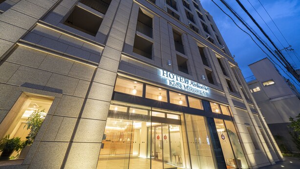 A hotel building with a modern facade, large glass windows, and a sign indicating it is the Kobe Motomachi Hotel. - Hotel Meriken Port Kobe Motomachi (Kobe)