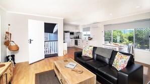Eine moderne Wohnung mit Wohnzimmer, Küche und Balkon.