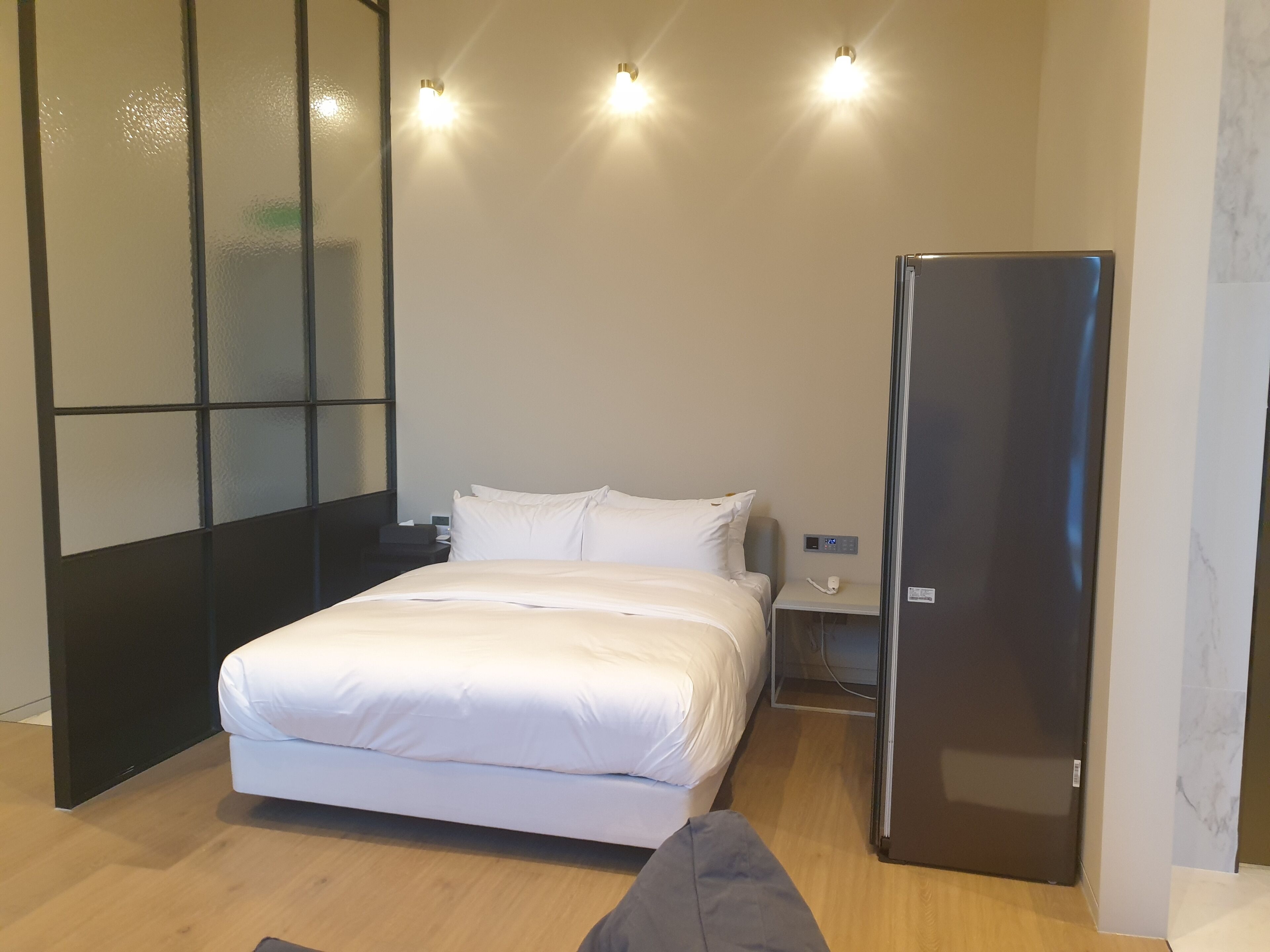 Un dormitorio moderno con cama, mesita de noche y armario empotrado.