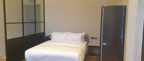 Un dormitorio moderno con cama, mesita de noche y armario empotrado.