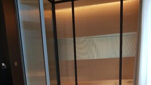A room with a bed in a corner, a small table, and a window with blinds. - Hotel Libre (Siheung)