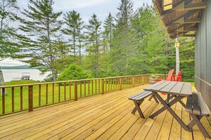 A wooden deck with picnic tables and chairs overlooking a lake. - Lakefront Escape w/ Deck & Kayaks in Lovell! (Lovell)