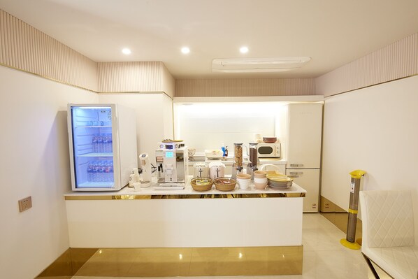 A kitchen area with a refrigerator, microwave, and various kitchen appliances. - Den Basta Hotel (Busan)