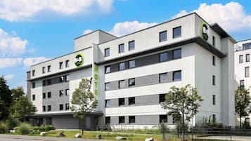 A modern B&B hotel with a flat facade, multiple windows, and a prominent green sign.