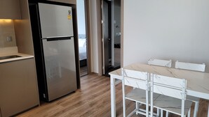 Uma cozinha moderna com geladeira embutida, uma mesa de jantar com cadeiras e piso de madeira.