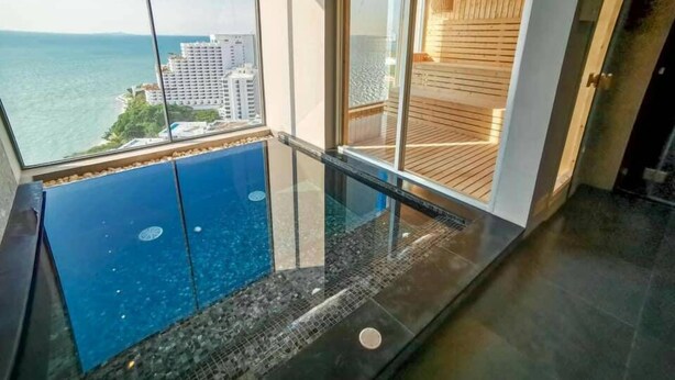 Varanda com guarda-vidro e vista para a cidade e para a água.