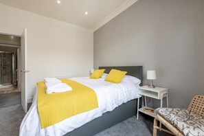 A bedroom with a bed, bedside table, and a chair. - No 67 Leuchars (Nr St Andrews) Free Parking - Pet Friendly (Leuchars)