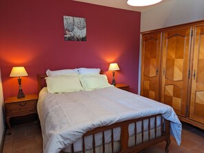 Classic hotel room with a wooden bed, two bedside tables, and a wardrobe featuring a geometric pattern.