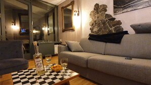 Een woonkamer met een tafelkleed, een bank en een decoratie van een stenen muur.