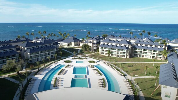 A resort with multiple buildings, a central pool area, and a view of the ocean. - Beachfront Apt - Playa Dorado, Puerto Plata (Puerto Plata,)