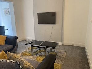 A living room with a black coffee table, a sofa, and a patterned rug. - The 5 bed House With Spacious Rooms and Lounge (Coventry)