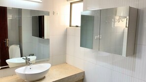 Een badkamer met twee wastafels, een grote spiegel en een raam.