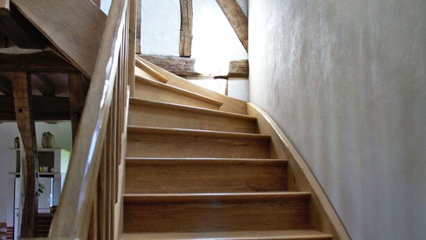 A wooden staircase with a handrail, leading to an upper floor. - Charming 2-Bedroom Rural House with Private Terrace Near Fontainebleau (Lorcy)