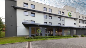 A B&B hotel with a modern design, featuring a flat roof, large windows, and a well-maintained garden area. - B&B HOTEL Essen-City (Essen)