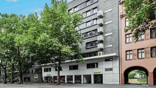 A modern hotel with multiple floors, a visible restaurant, and a B&B sign. - B&B Hotel Frankfurt City-Ost (Frankfurt)