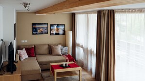 A modern living room with a sofa, a coffee table, and a TV. - 1: Three-room Apartment With Panoramic View (Badia)
