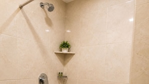 A bathroom with a shower, a toilet, and a sink. - Room-la Riviera Suites Premium Stay in (Hyderabad)