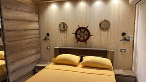 Une pièce avec un lit, des murs en bois, un gouvernail de bateau et un miroir.