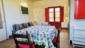 A room with a bed, a chair, a table, and a red door. - Agricontura: House of Lemons with shared swimming pool and breakfast room (Contura)