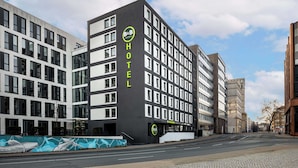 Een modern hotelgebouw met een opvallend 'B&B HOTEL' bord, meerdere verdiepingen en een heldere lucht.