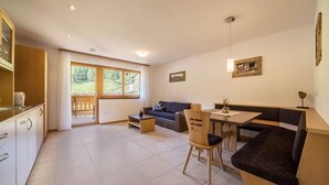 Una cocina moderna con comedor, sofá y una mesa con sillas.