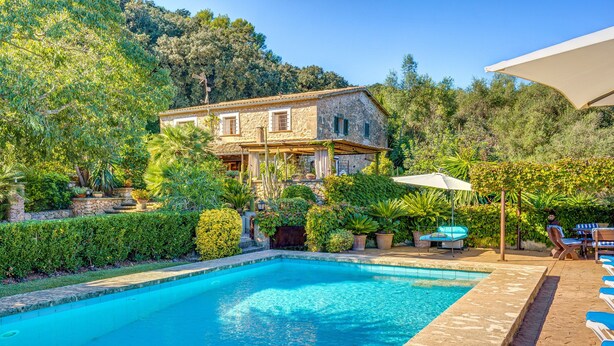 A pool with clear water, a stone house with a balcony, and surrounding greenery. - "Ca les Estamenyes" near the sea, Wi-Fi, air conditioning, garden and pool (POLLENÇA)