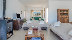 Une chambre à coucher avec un lit, une table en bois, une télévision et une armoire.