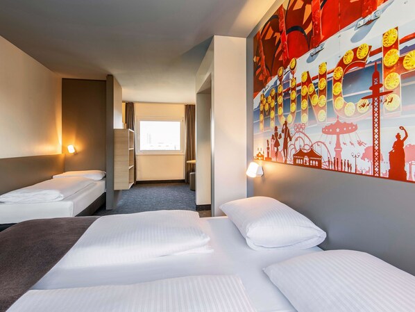 A hotel room with two beds, a large window, a wall-mounted artwork, and a door leading to another room. - B&B Hotel München City-West (Munich)