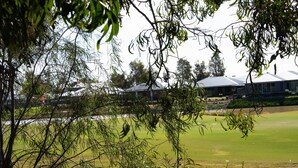 A view of a golf course with a building in the background.