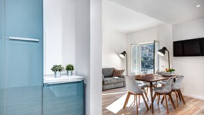 Une cuisine moderne avec des meubles bleus et un coin repas comprenant une table et des chaises en bois.