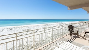 A balcony with a view of a beach and ocean.