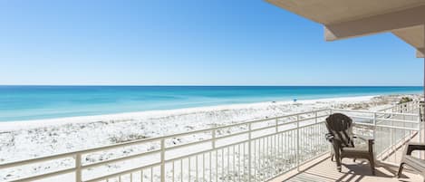 A balcony with a view of a beach and ocean.