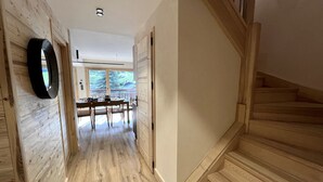 Un interno in legno con una scala, un'area da pranzo e una vista dalla finestra.