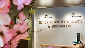 A reception desk at the Beach Hotel Santalahi & Restaurant with a modern design and a sign above it.