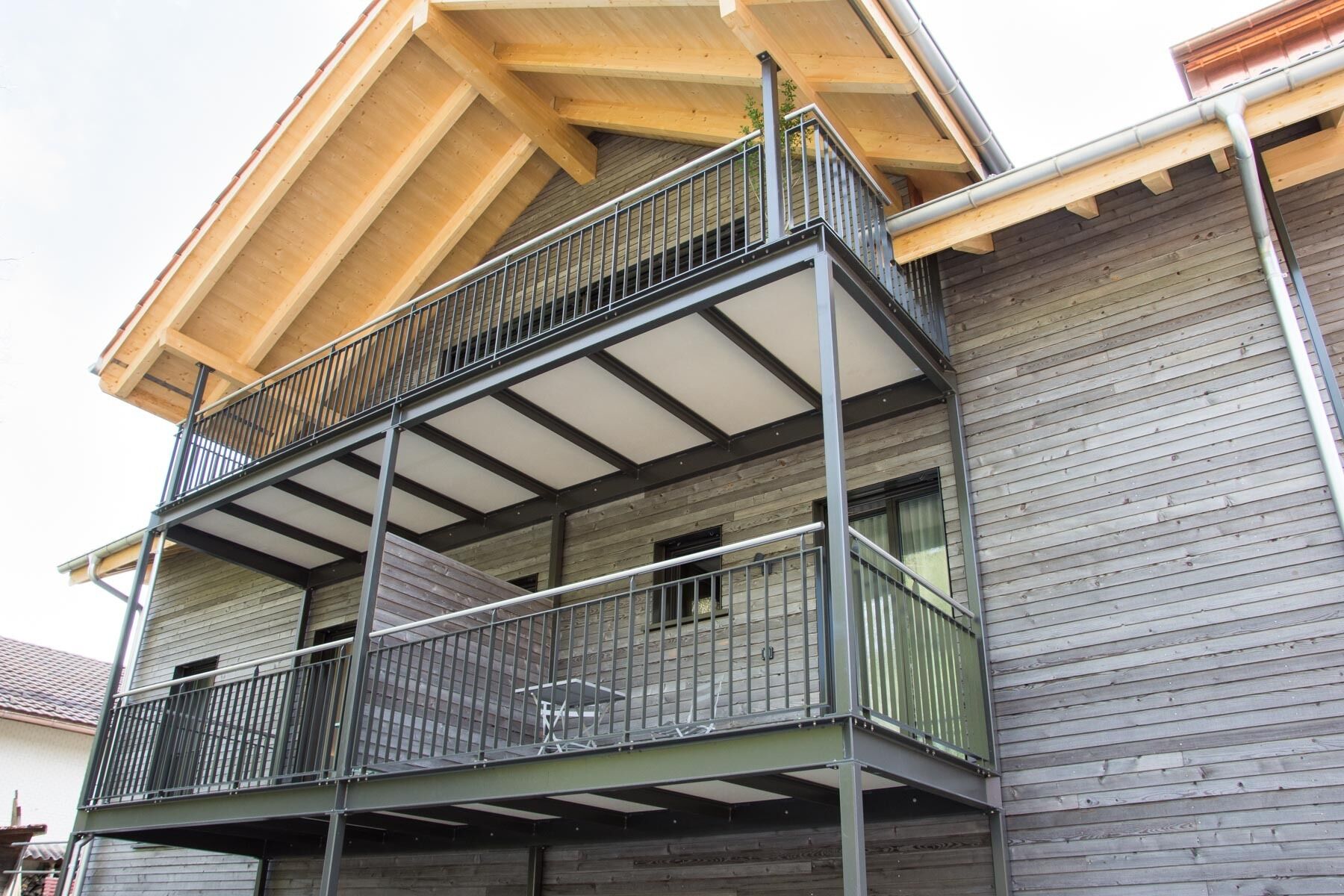 Ein mehrgeschossiges Gebäude mit einem Balkon im zweiten Stock.