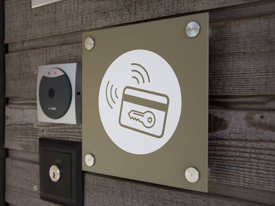 A wall-mounted sign with a Wi-Fi symbol and a credit card symbol, indicating payment and connectivity options.