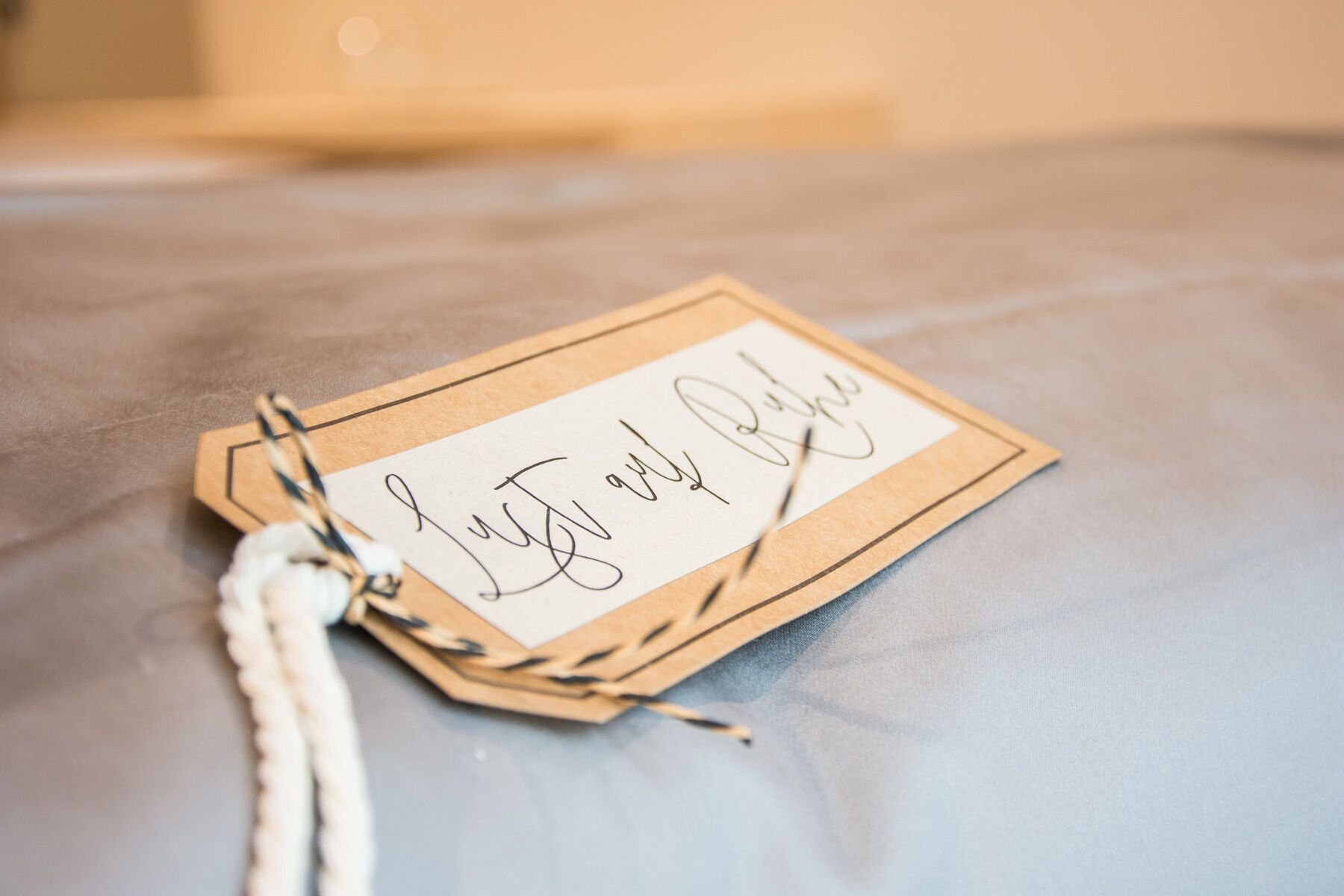 A tag with handwritten text on a textured surface.