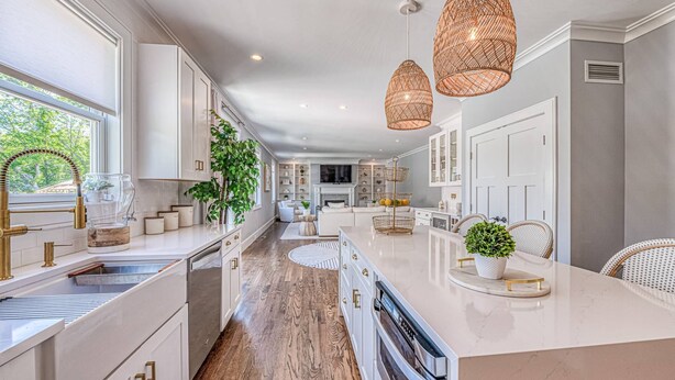 Una cocina moderna con armarios blancos, una isla central e iluminación colgante.