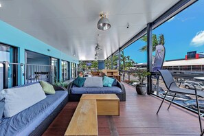 A modern outdoor seating area with a sofa, chairs, and a wooden table.