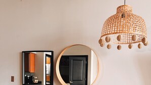 A dining area with a wooden table and chairs, a mirror, and a hanging light fixture. - KING SUITE Loft Downtown 420 friendly - FREE PARKING - FREE Wifi (Detroit)