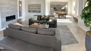 A spacious living room with a gray sofa, a coffee table, and a fireplace. - Southern Utah Vacationing at Its Best! (Hurricane)