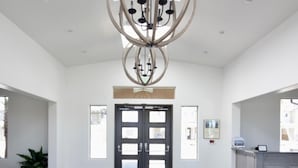 A spacious interior with a modern chandelier, a double door entrance, and a view of the outside. - Southern Utah Vacationing at Its Best! (Hurricane)