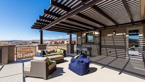 A rooftop patio with outdoor furniture, a foosball table, and a view of the surrounding landscape. - Southern Utah Vacationing at Its Best! (Hurricane)
