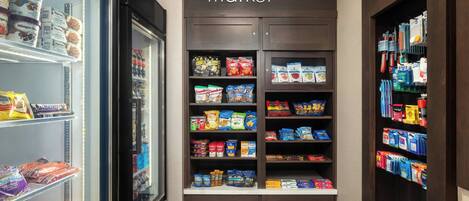 Interior de una tienda de comestibles con una variedad de snacks, bebidas y productos lácteos en los estantes.