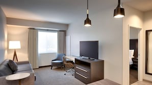 A hotel room with a sofa, a desk, a television, and a dining table. - Residence Inn by Marriott San Marcos (San Marcos)